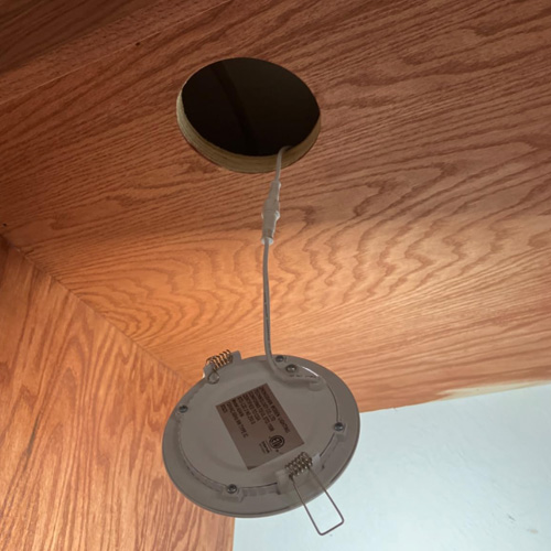 Cutting openings for recessed lighting in ceilings.